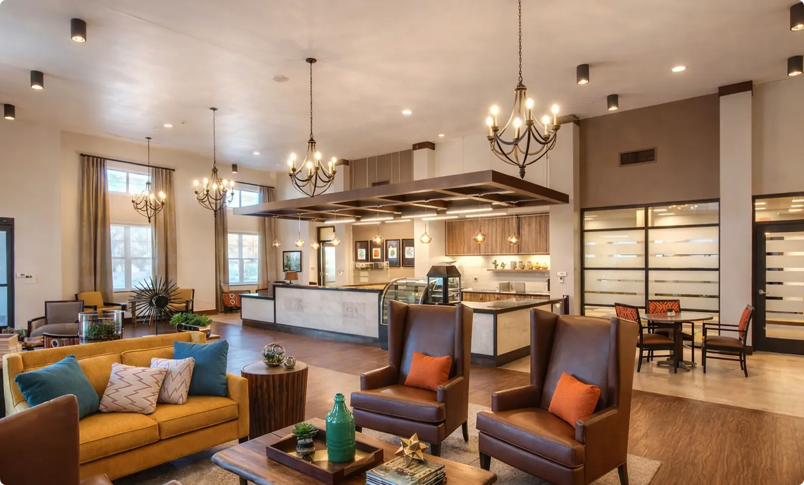 A residential living room with lounge seating and an open kitchen view