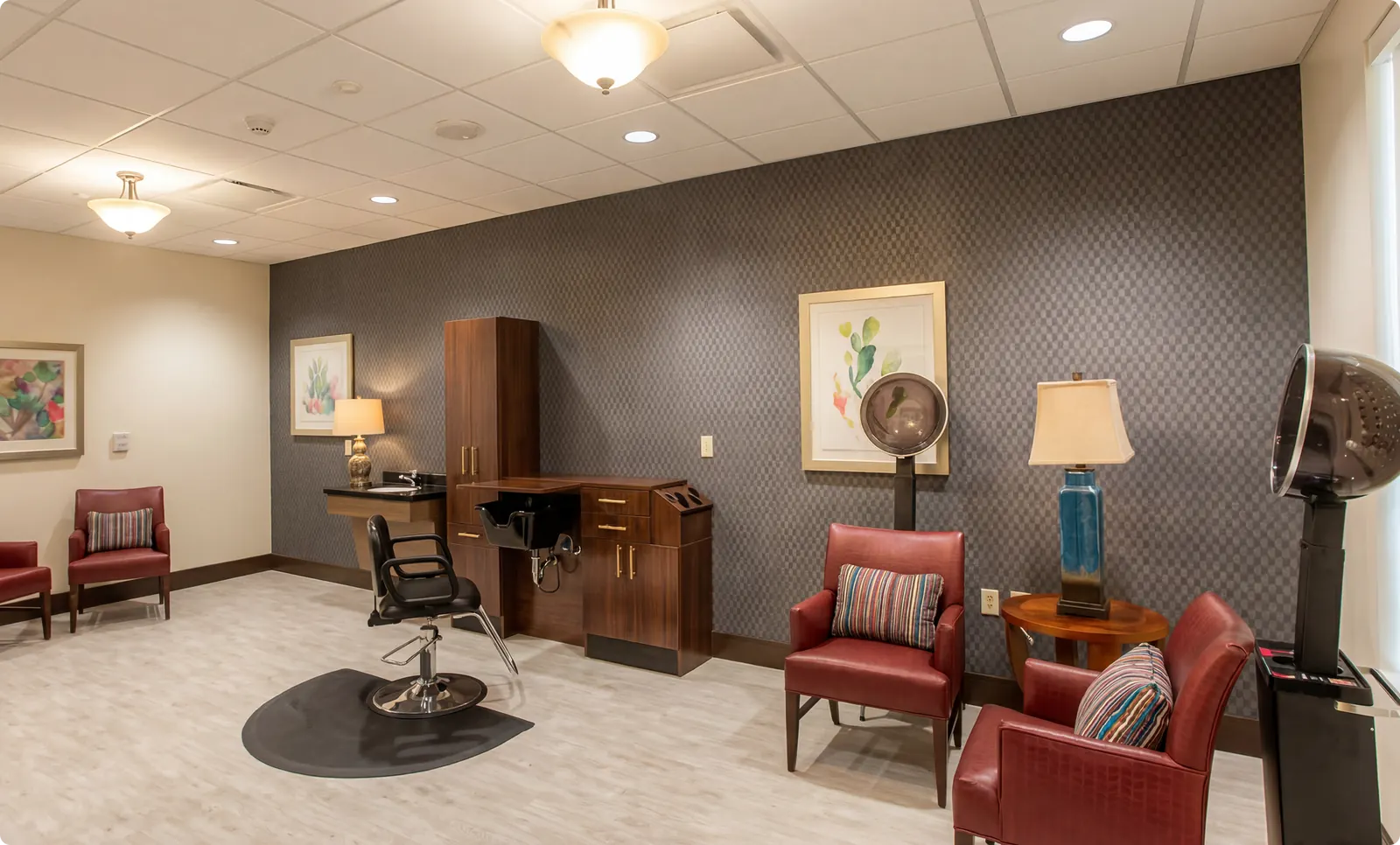 A salon and personal care room with a styling chair and mirrors