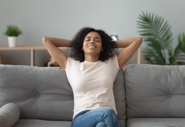 Serene woman leaned on couch resting at home