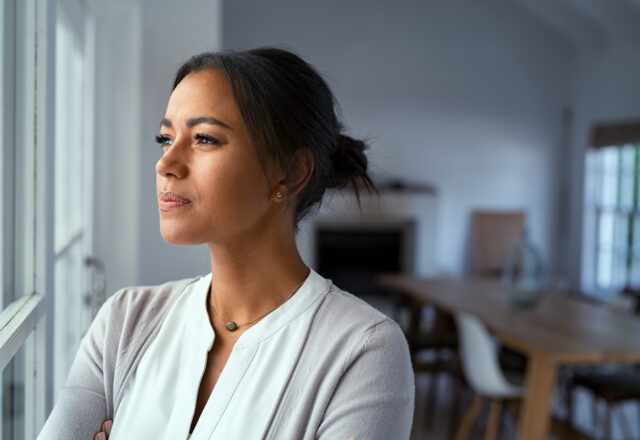 Thoughtful woman looking outside window