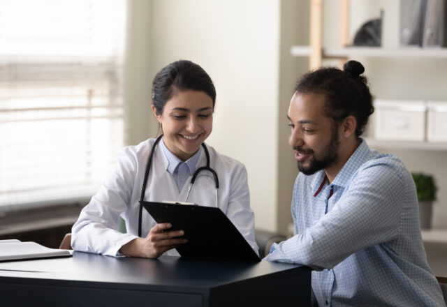 Happy young doctor discussing treatment with patient.