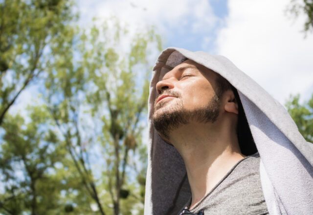 Carefree man enjoying in sunshine with eyes closed..