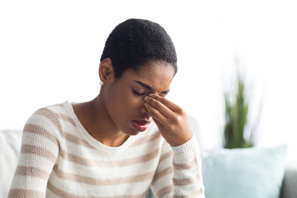 Sick Young Woman Touching Her Nose Bridge At Home