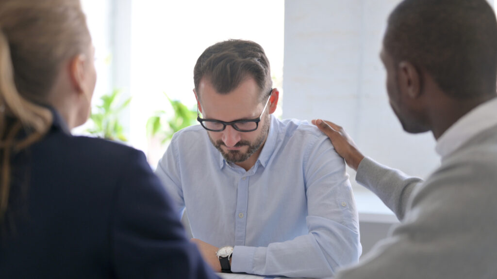 Business People Reassuring Upset Businessman