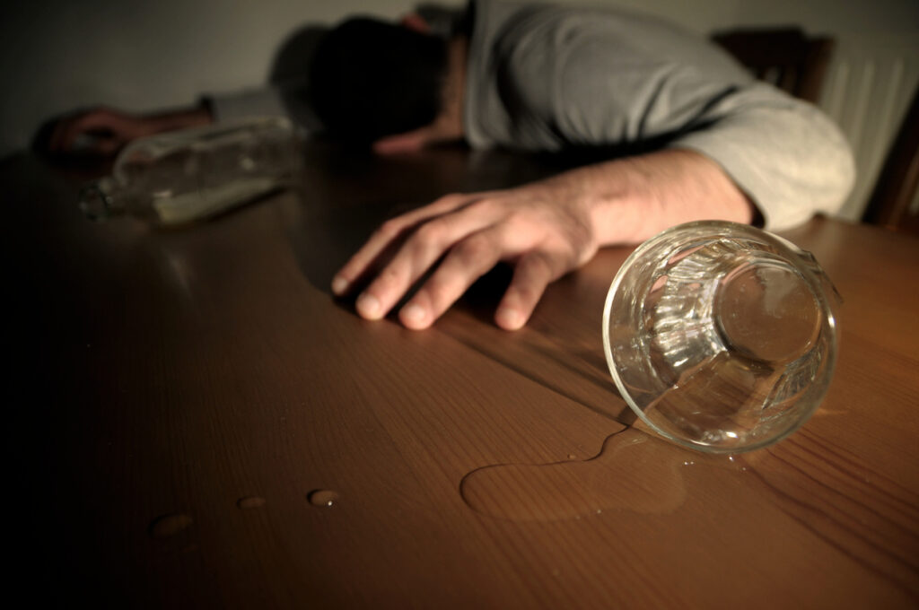 Alcoholism Concept Man Drunk Laying on the Table